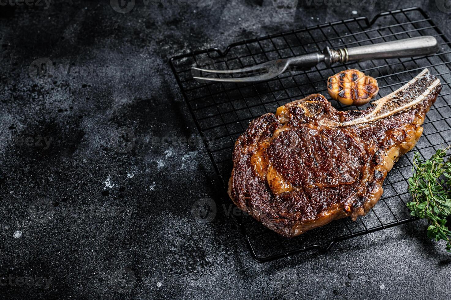 BBQ Grilled Tomahawk or rib eye with bone beef steak. Black background. Top view. Copy space photo