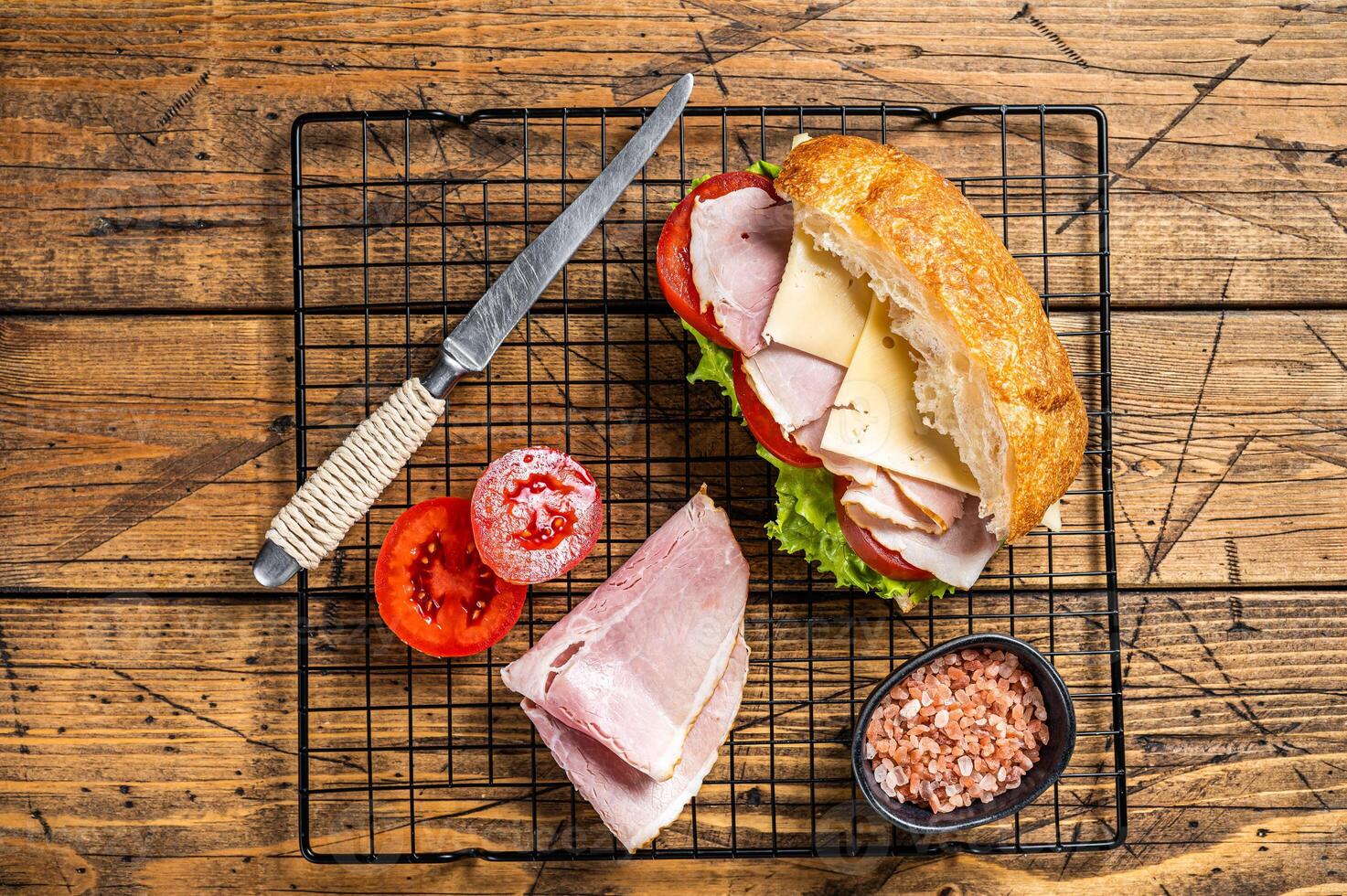 Sub sandwich with ham, cheese, tomato and Lettuce. Wooden background. Top view photo