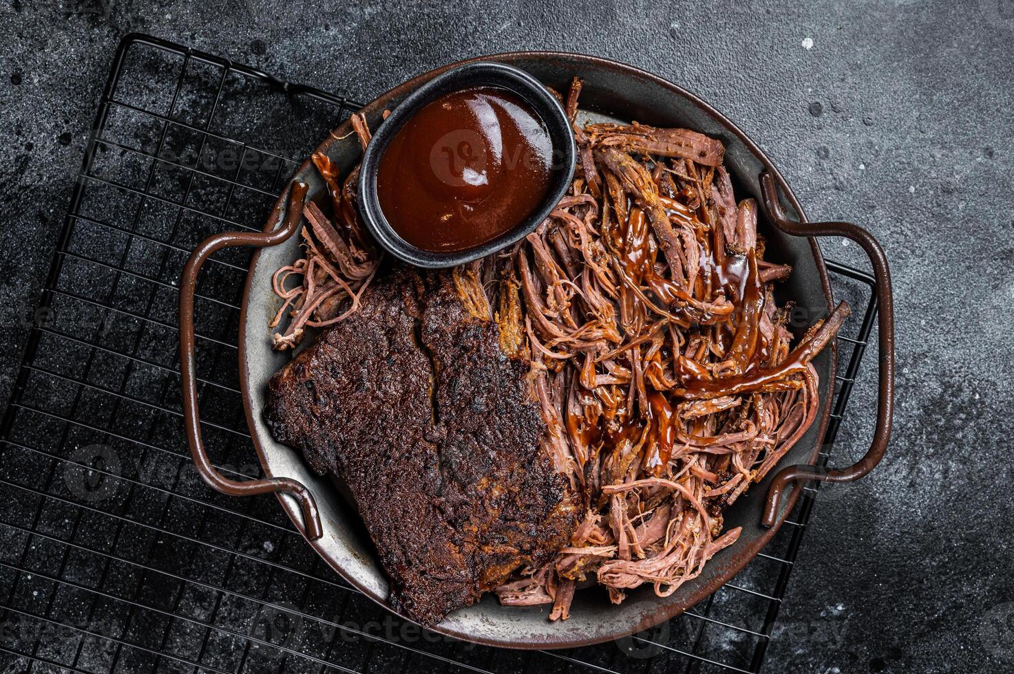 Slow Cooked Pulled Beef, Traditional meat rubbed with spices and smoked in a Texas smoker. Black background. Top view photo