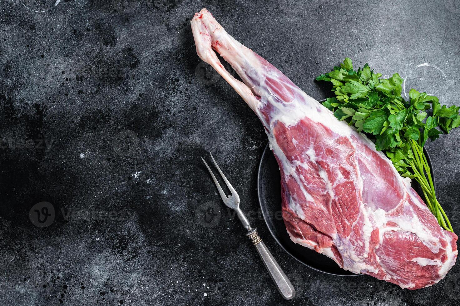 Ready for cooking raw lamb mutton leg with Thigh. Black background. Top view. Copy space photo