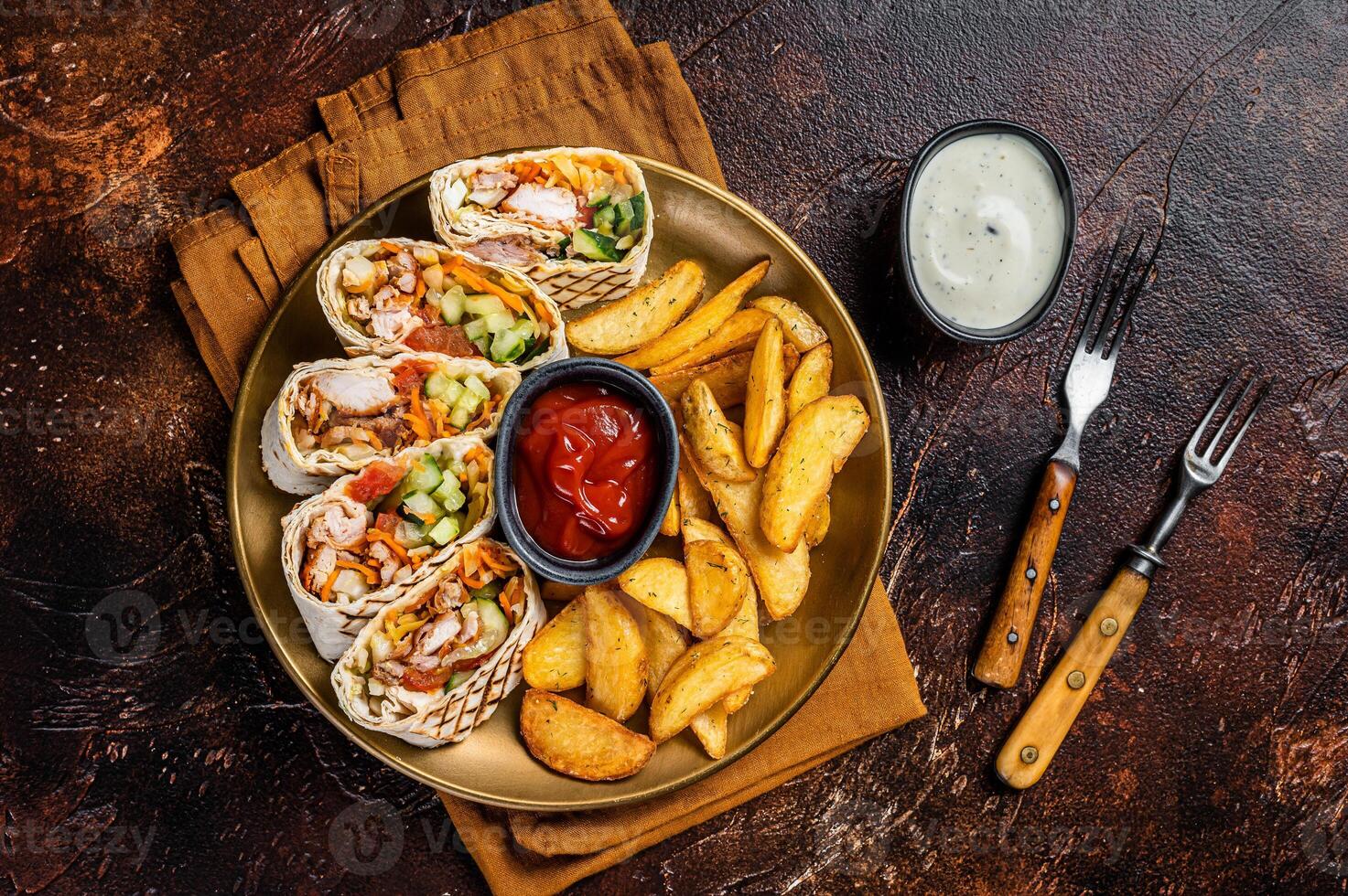Chicken shawarma durum doner kebab with vegetable salad and french fries. Dark background. Top view photo