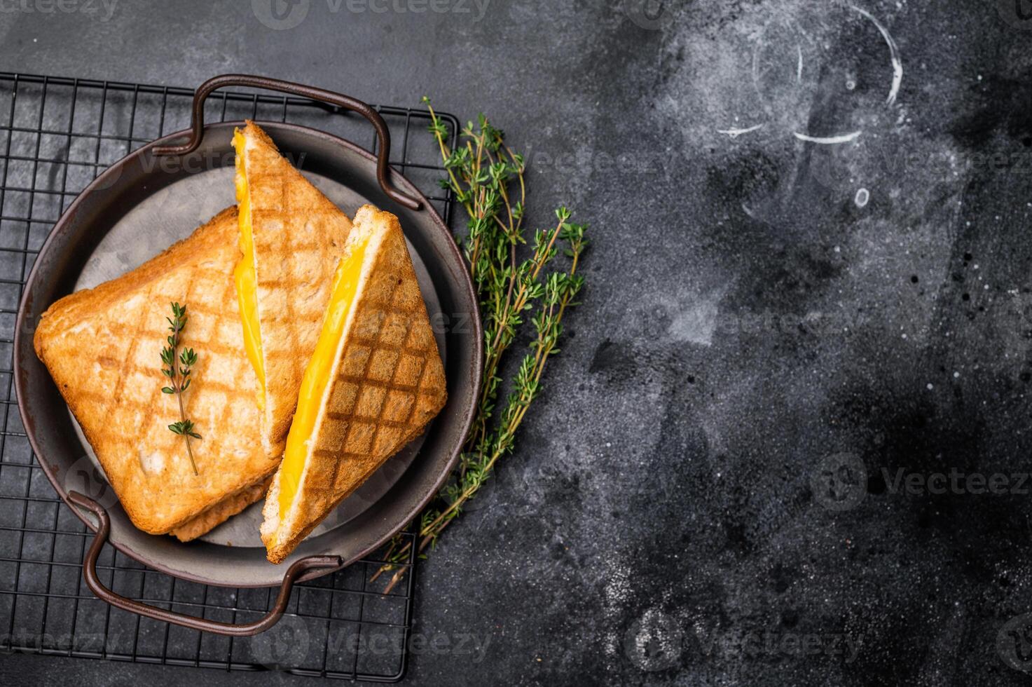 Toasted sliced cheese sandwiches in steel tray. black background. top view photo