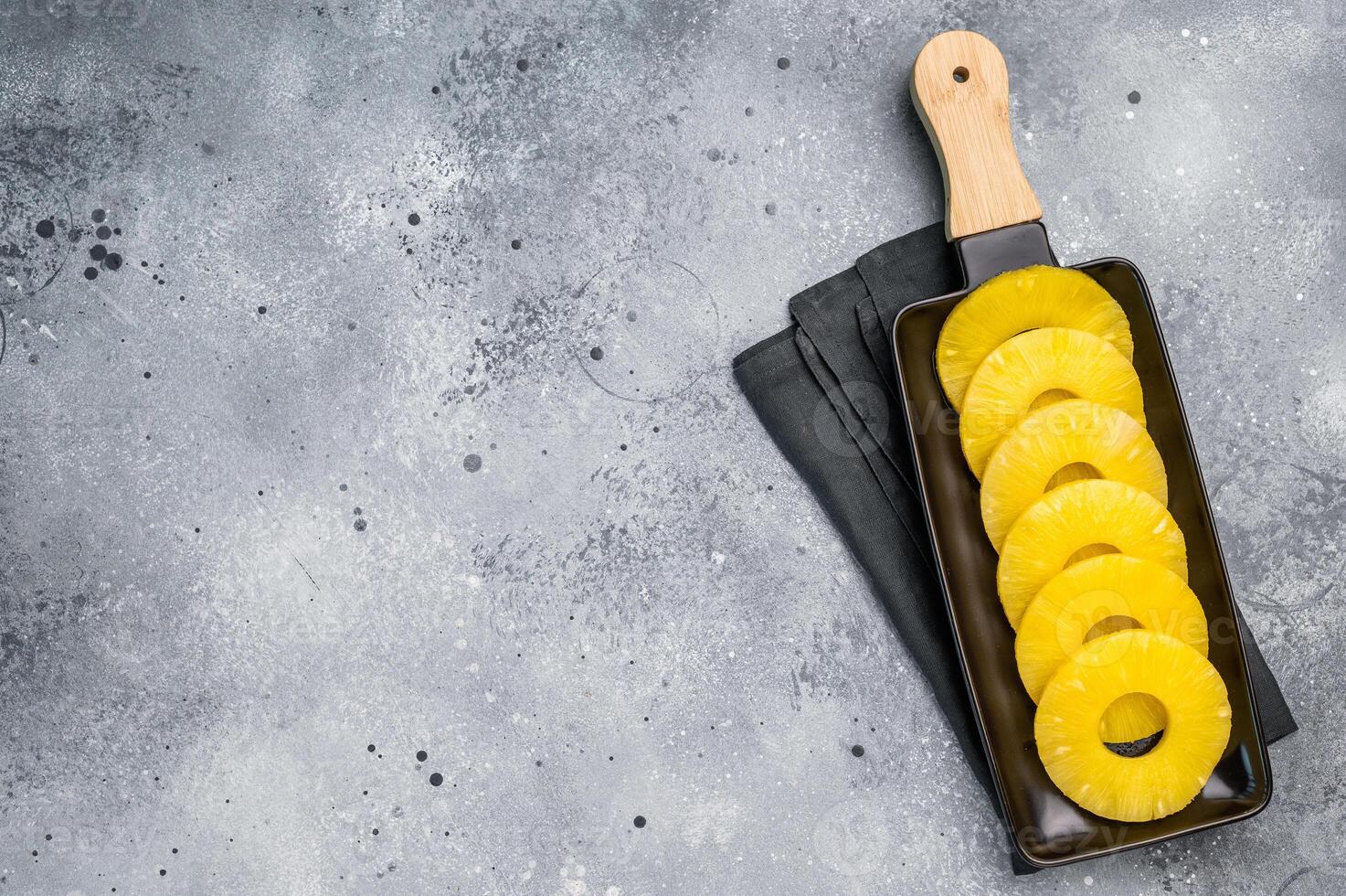 Canned Pineapple rings slices on a board. grey background. top view photo