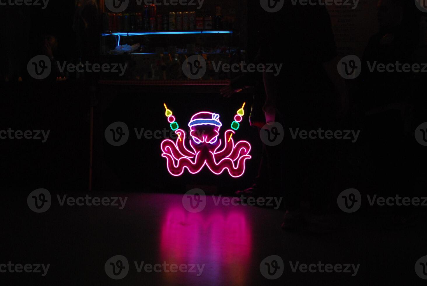 A Neon Octopus Sign Elegantly Illuminating the Vibrant Atmosphere of a Trendy Bar Locale photo
