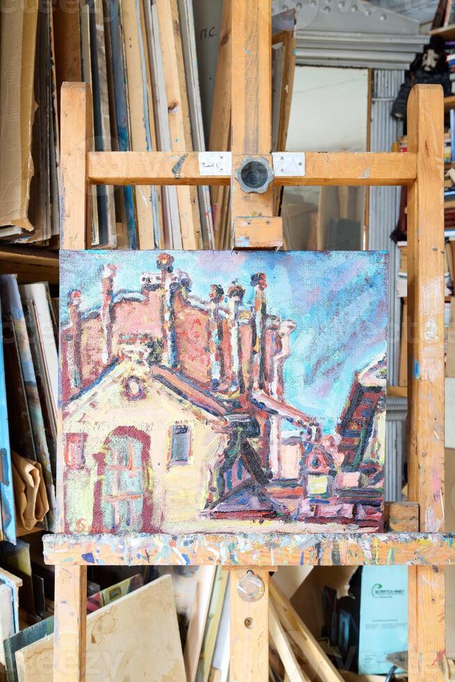 A Stunning Vibrant ImpressionistStyle Painting of Rooftops Displayed on an Easel photo