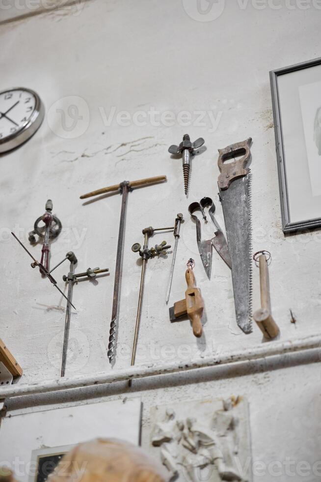 A Beautiful Collection of Vintage Tools Elegantly Hanging on a Workshop Wall for Display photo