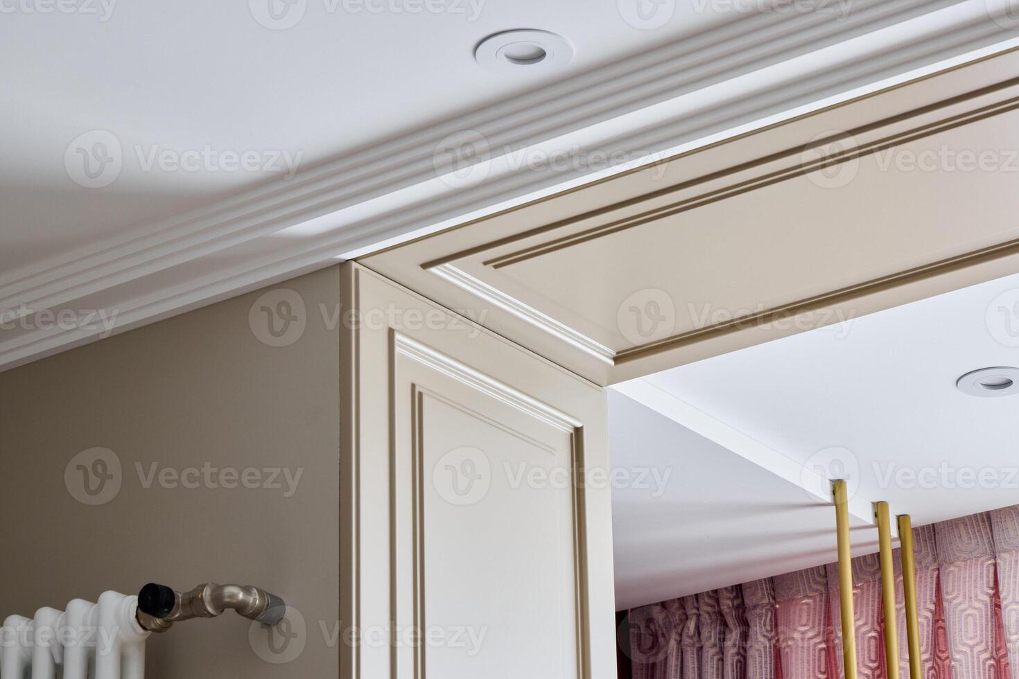 An Elegant Interior Corner Designed with Beautiful Crown Molding and Stylish Light Fixtures photo