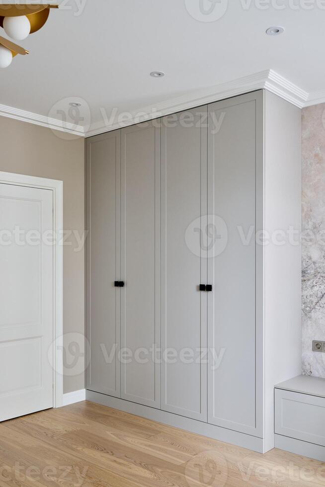A Modern Bedroom Featuring a Stylish Wardrobe Accompanied by Elegant Wooden Flooring photo