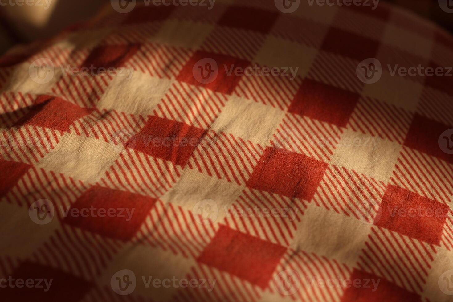 A beautifully textured fabric that features a checkered pattern in red and cream colors photo