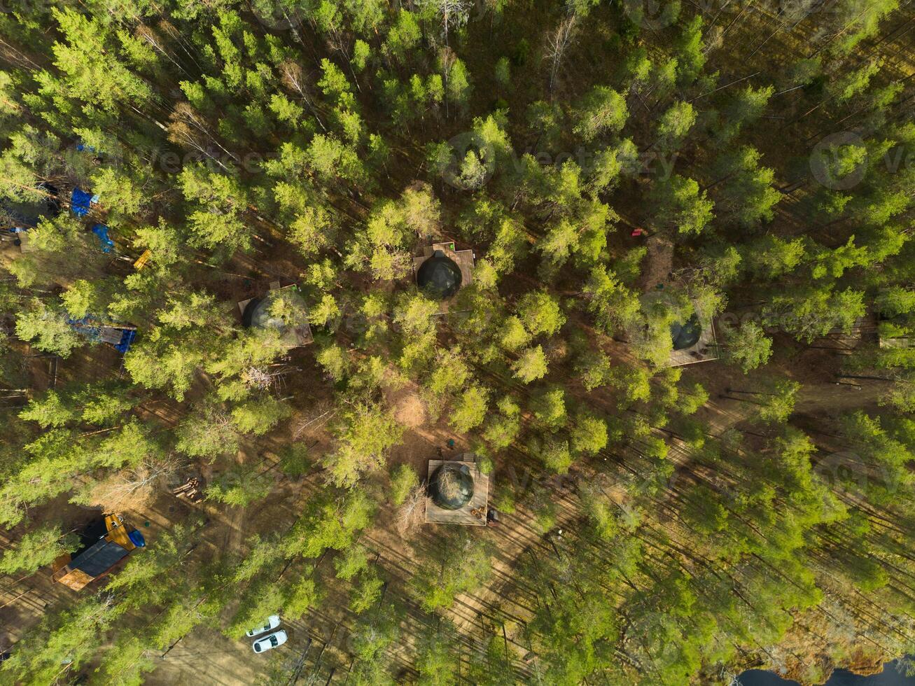 A Stunning Aerial View of a Lush Forest Surrounded by Cozy Cabins in a Natural Setting photo
