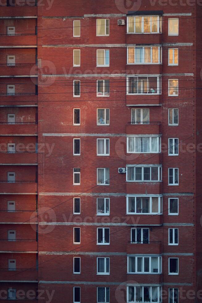 An Urban Architectural Facade Showcasing Windows That Are Beautifully Illuminated During Sunset Time photo