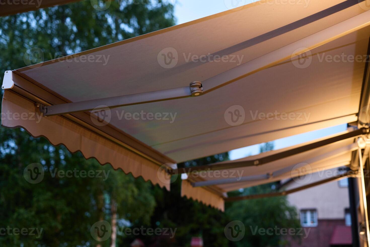 An Elegant Outdoor Awning with Warm Lighting that Creates Ambiance at Dusk During Evening Hours photo
