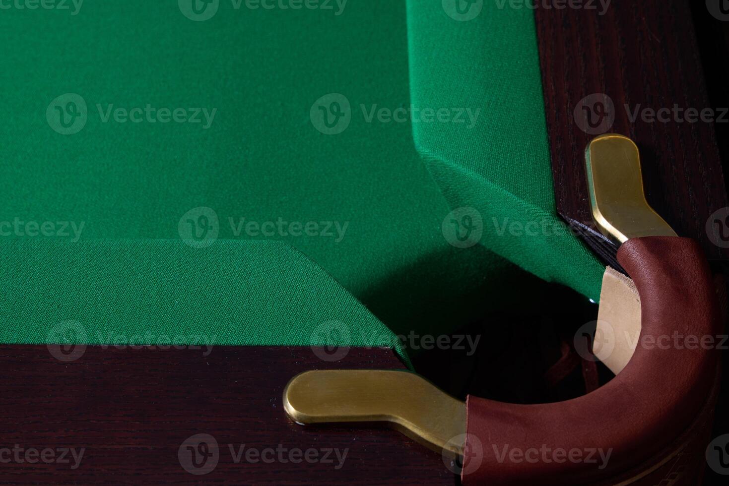 A CloseUp View of a Corner of a Billiards Pool Table Featuring Green Felt and Elegant Brass Details photo