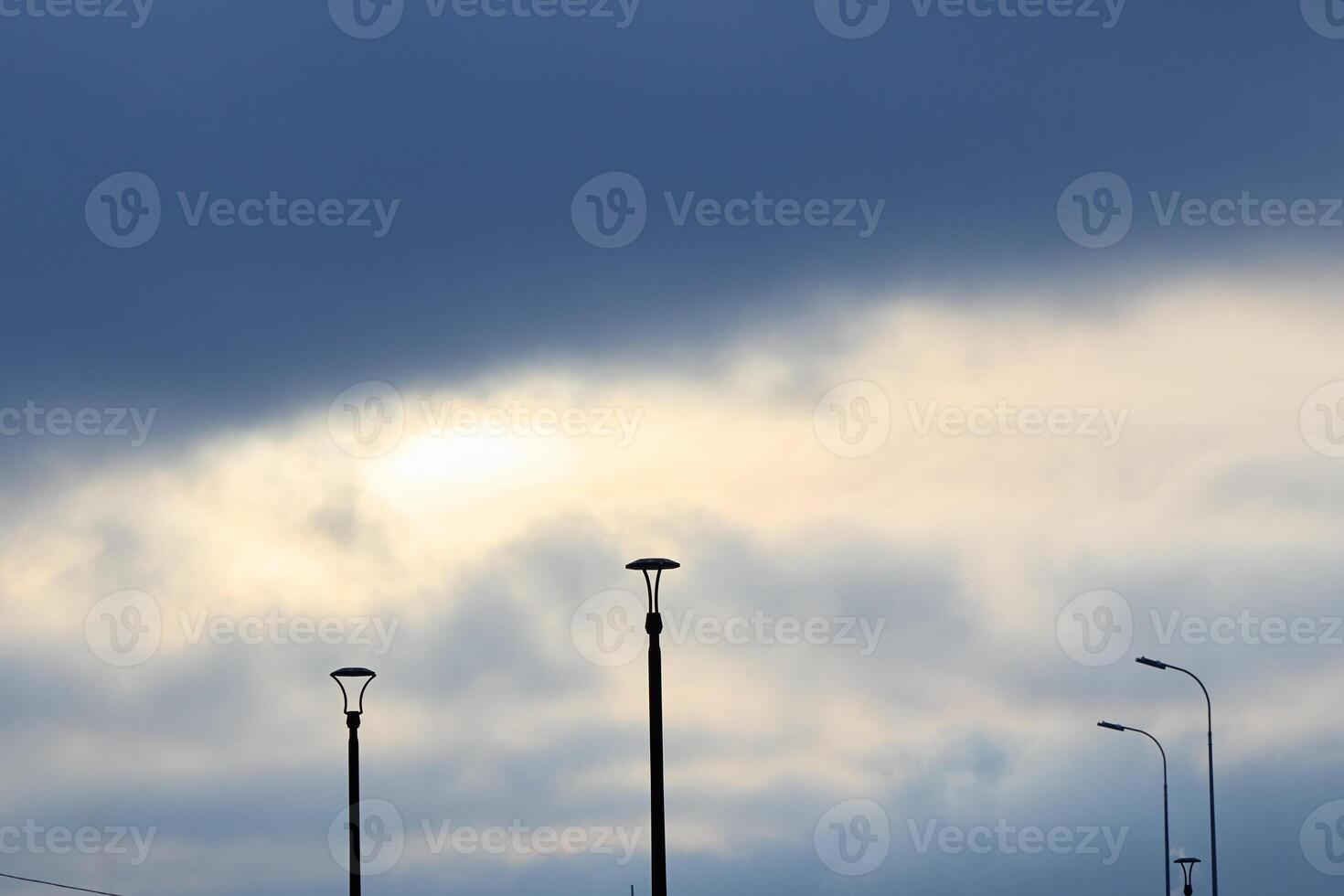 A Stunning Cloudy Sky With Street Lights Beautifully Depicted in Silhouette Form photo