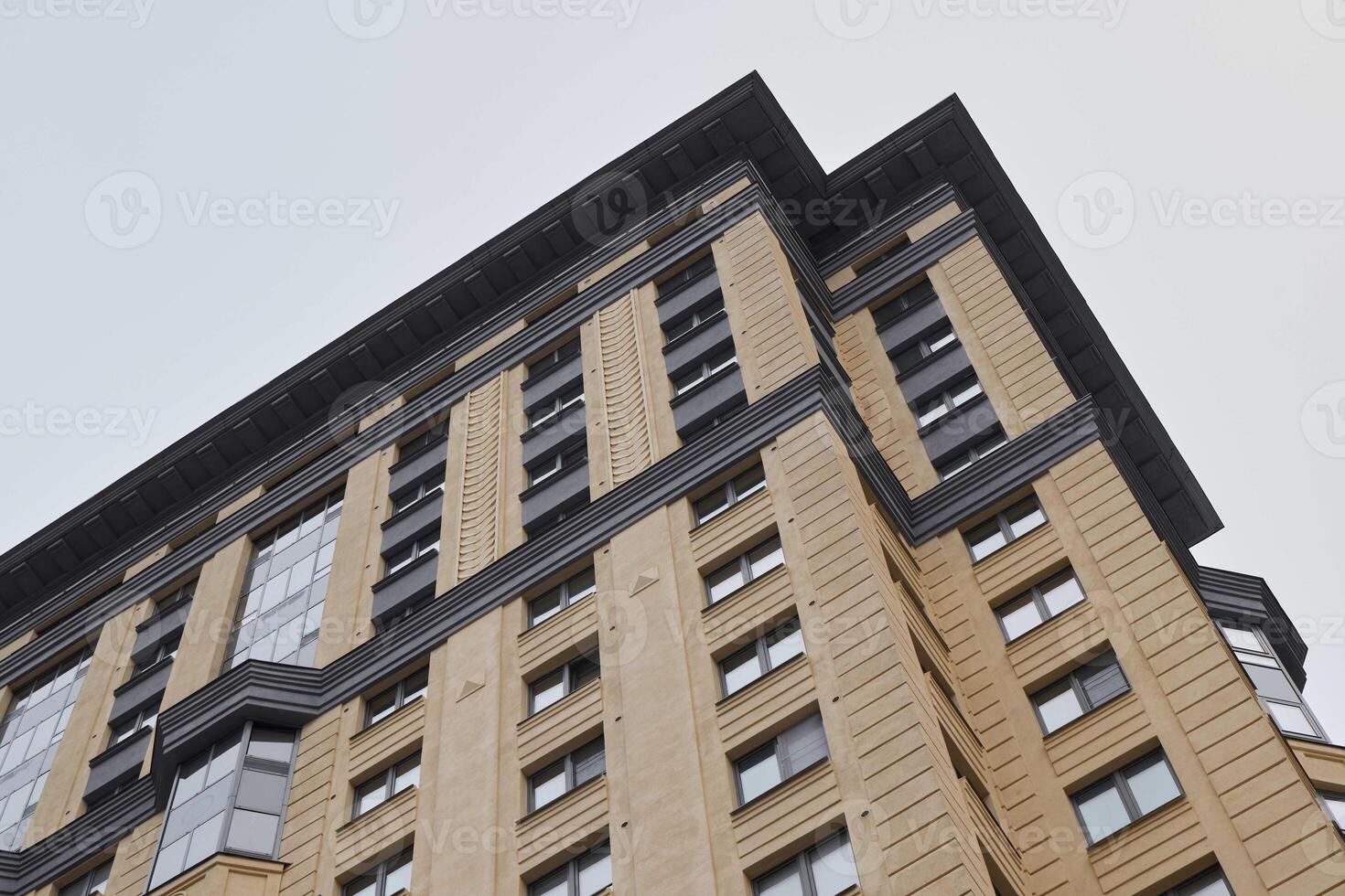 A Detailed View of Modern Architecture Showcasing an Urban Building Set Against a Grey Sky photo