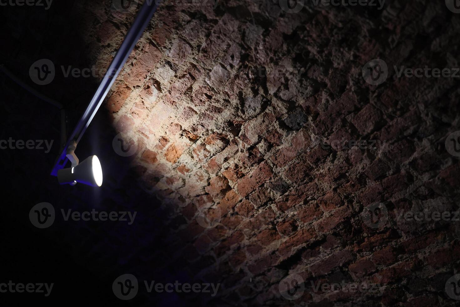 An Illuminated Brick Wall Standing Out Distinctly Within a Dark Environment Setting photo