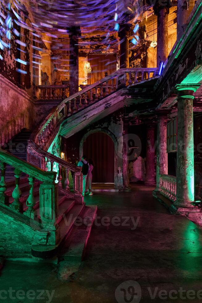 Experience the Haunting Elegance of an Abandoned Staircase illuminated by Dramatic Lighting photo