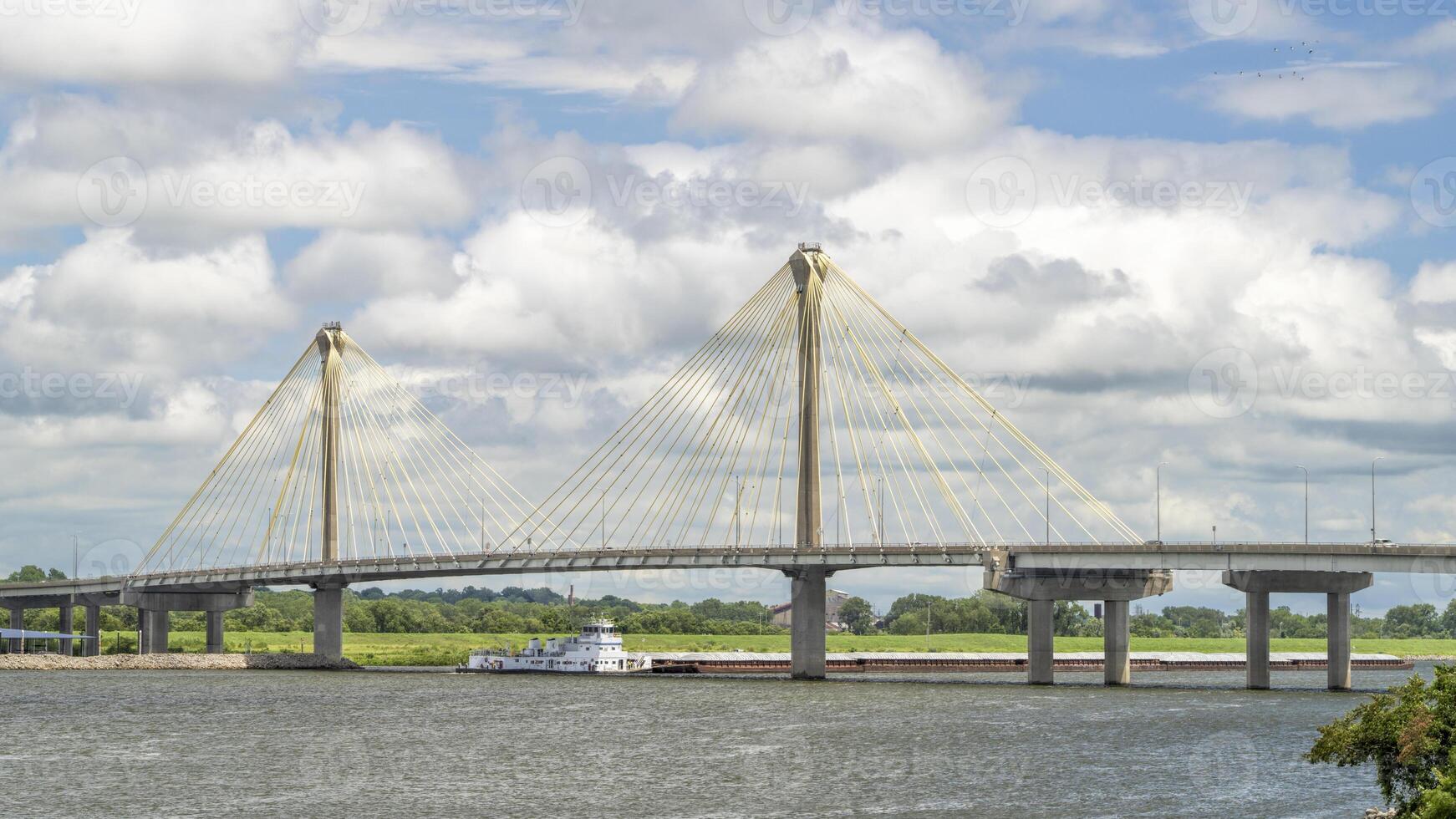 towboat with barges os passing under the Clark Bridge, a cable-stayed bridge across the Mississippi River between West Alton, Missouri and Alton, Illinois. photo