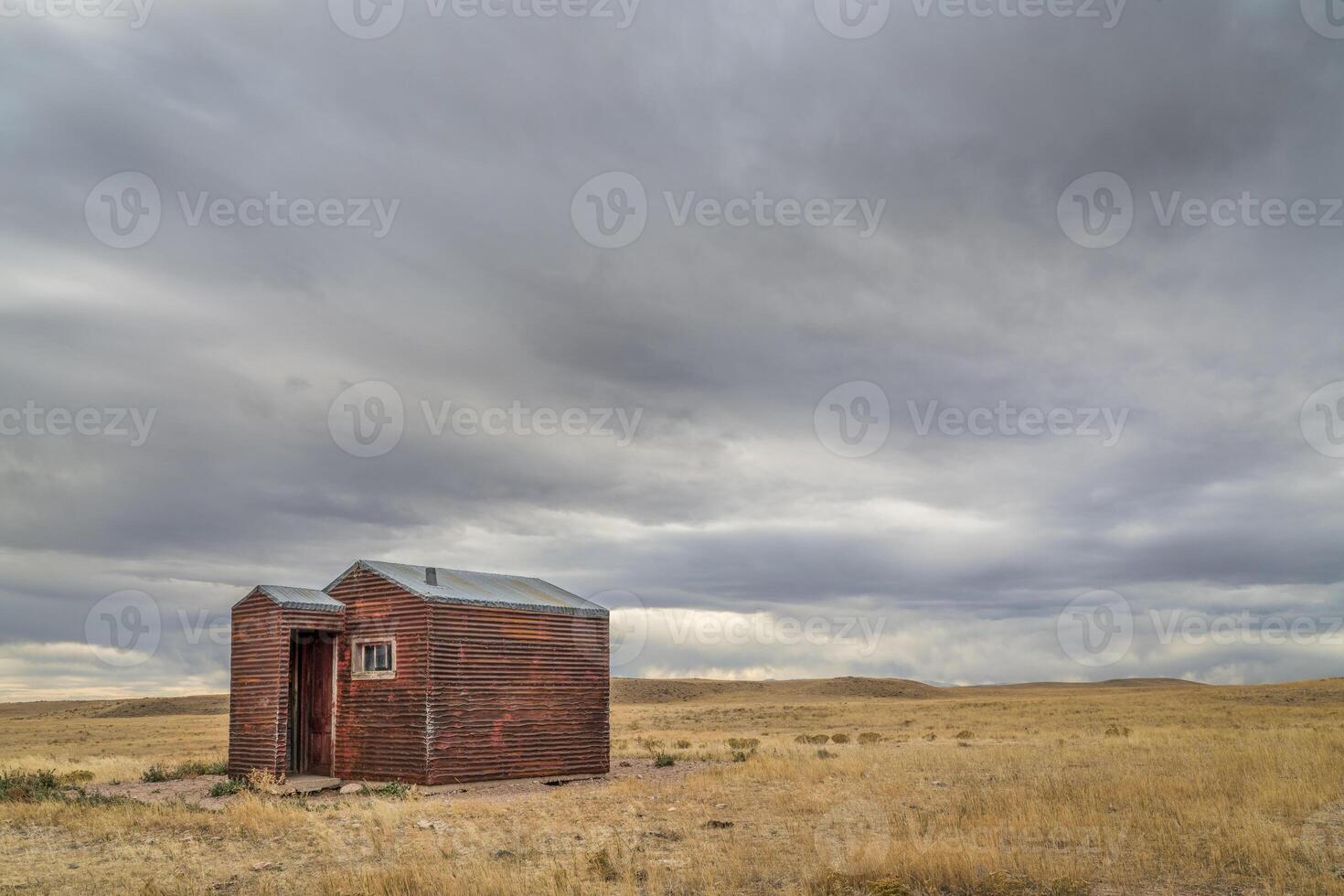 old, metal, rusty shack on a prairie photo