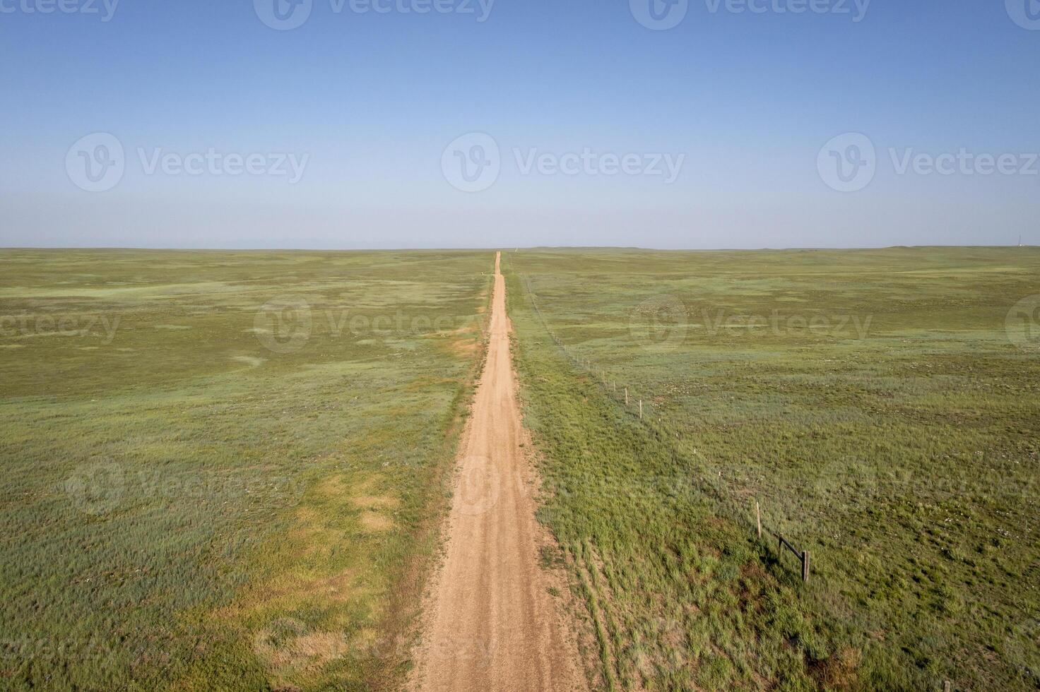 dirt remote road going through green prairie photo