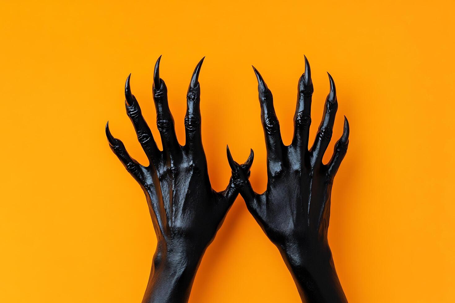 Hands of a black woman with claws on orange background photo