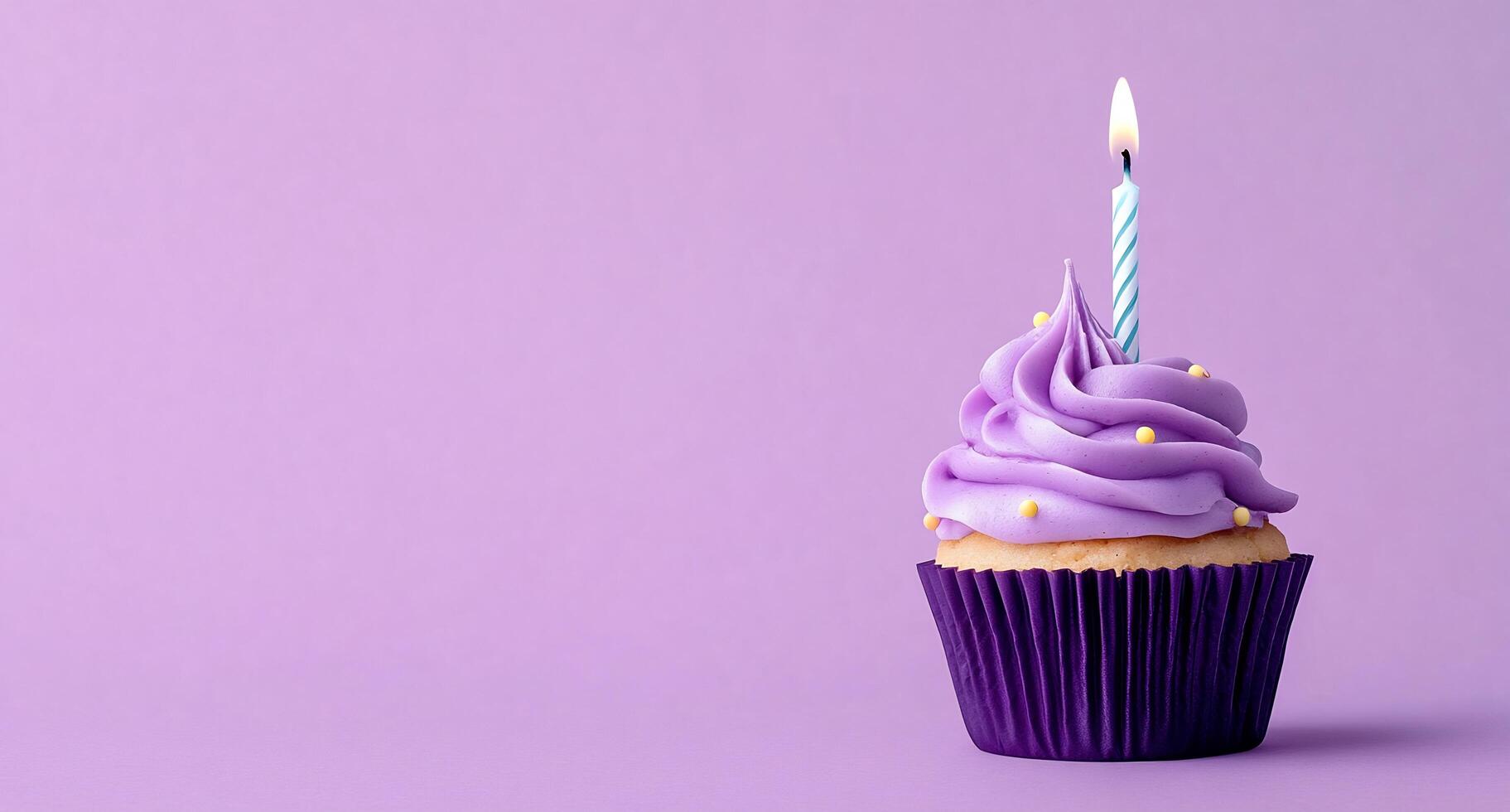A cupcake with a single candle on a purple background photo