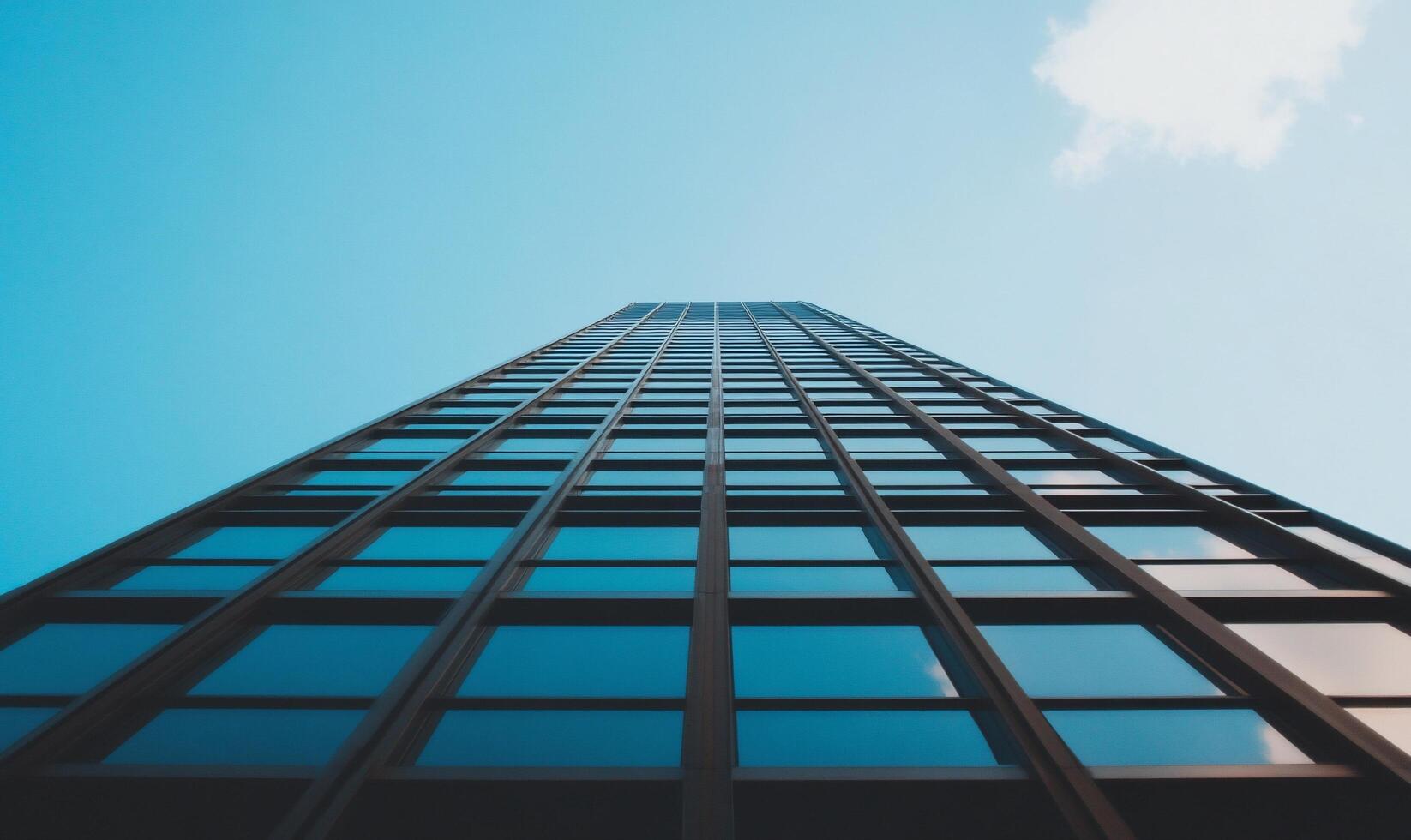 A tall building viewed from below against a clear blue sky. photo