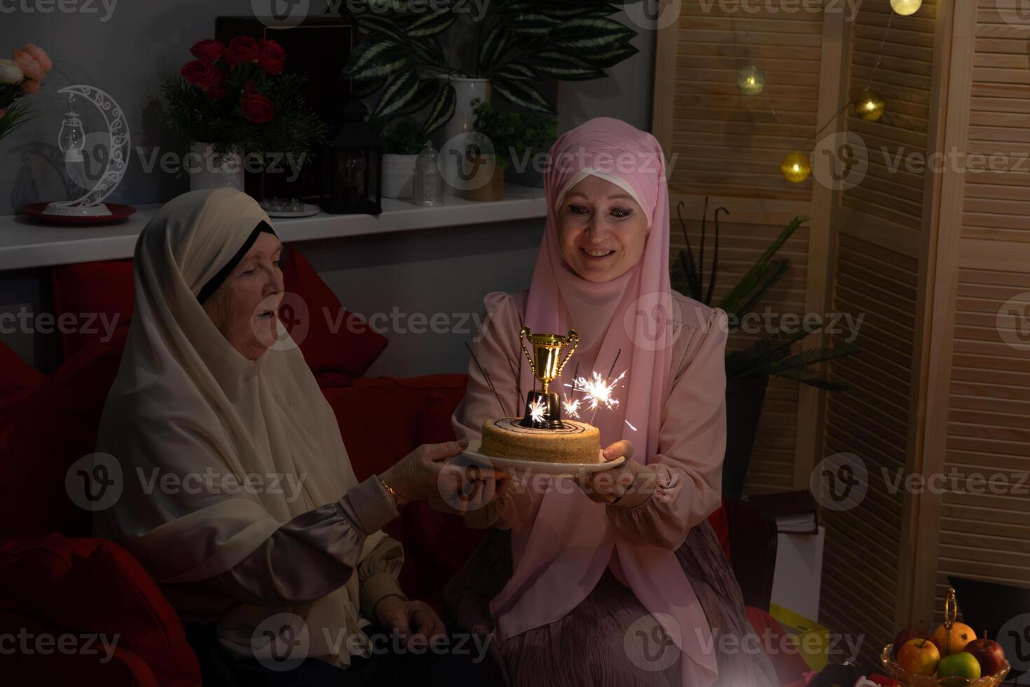 A woman holding a cake with a candle on it photo