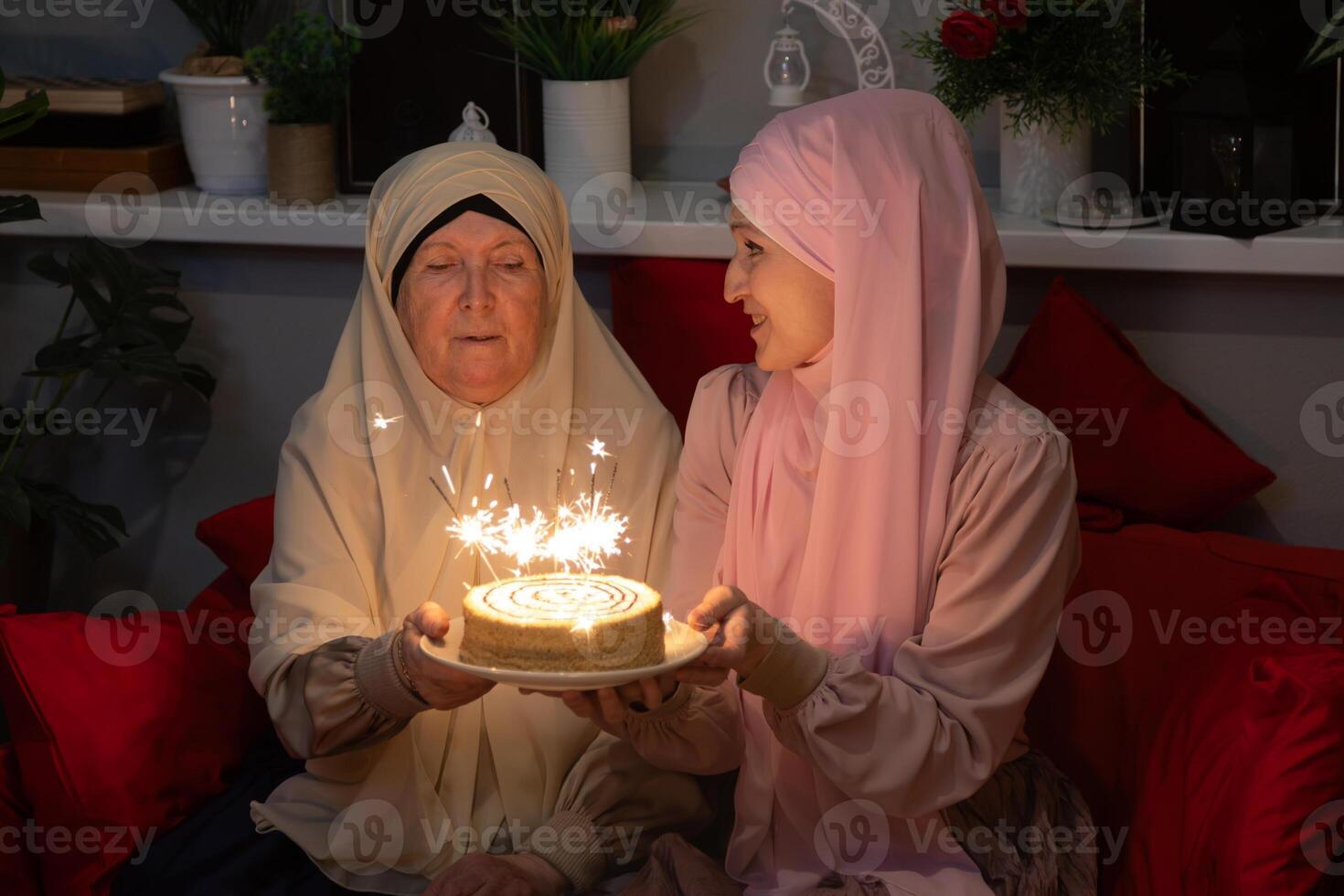 A woman holding a cake with sparklers photo