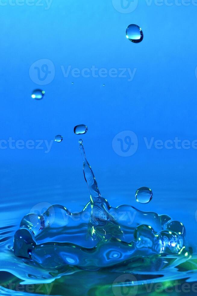 High-speed photograph of a water drop impacting on water showing secondary drops formation photo