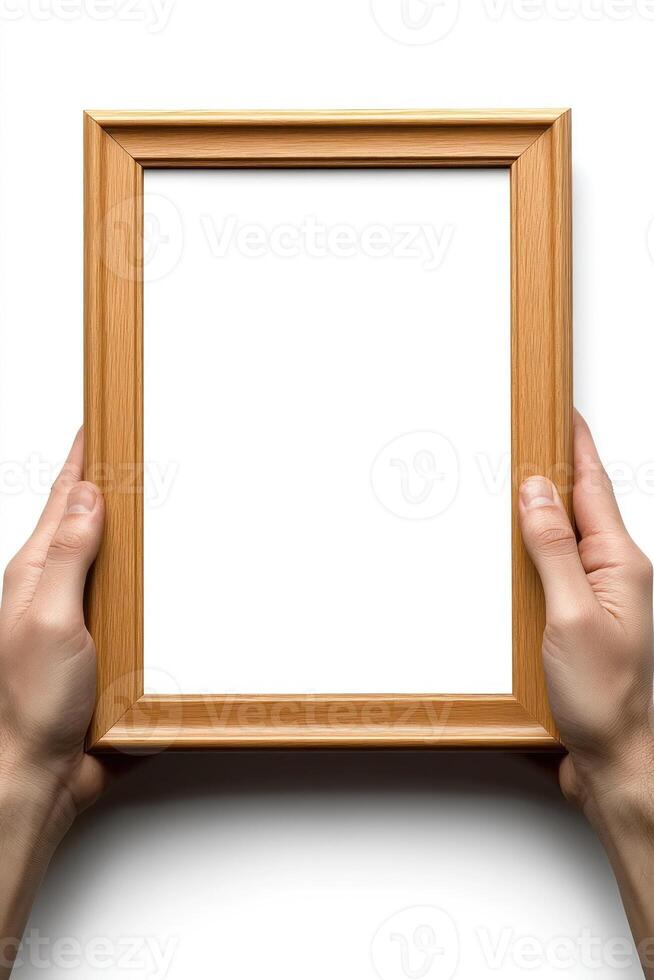 Two hands grasp a wooden frame, positioning it for an empty space ready for artwork or photos