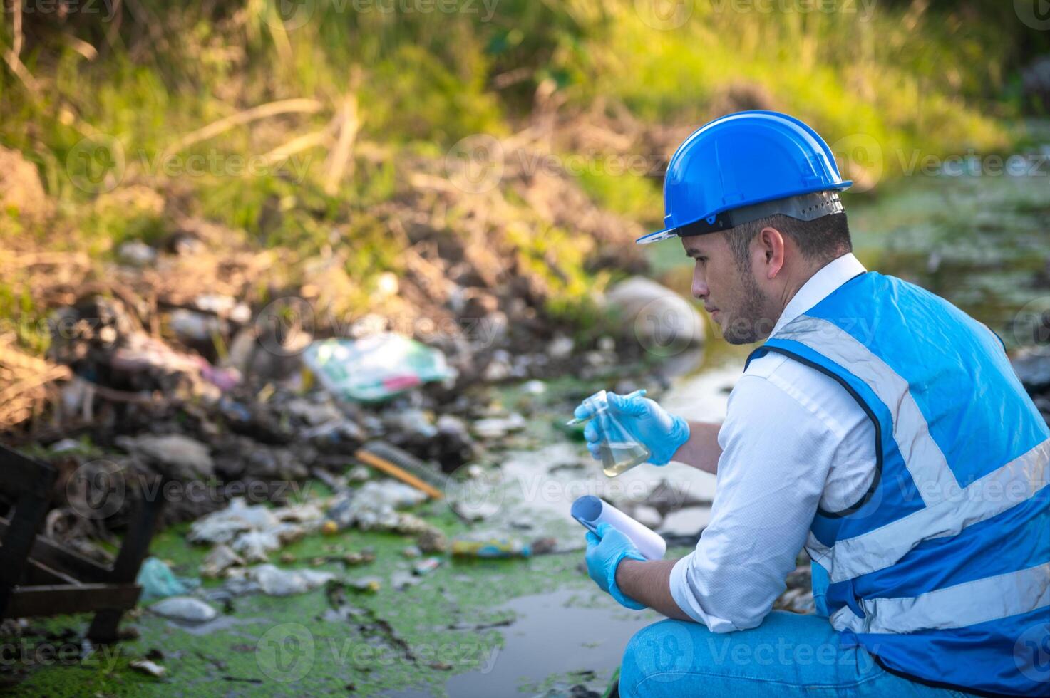 Water resource experts check the water quality in a community canal contaminated with garbage in the canal. photo