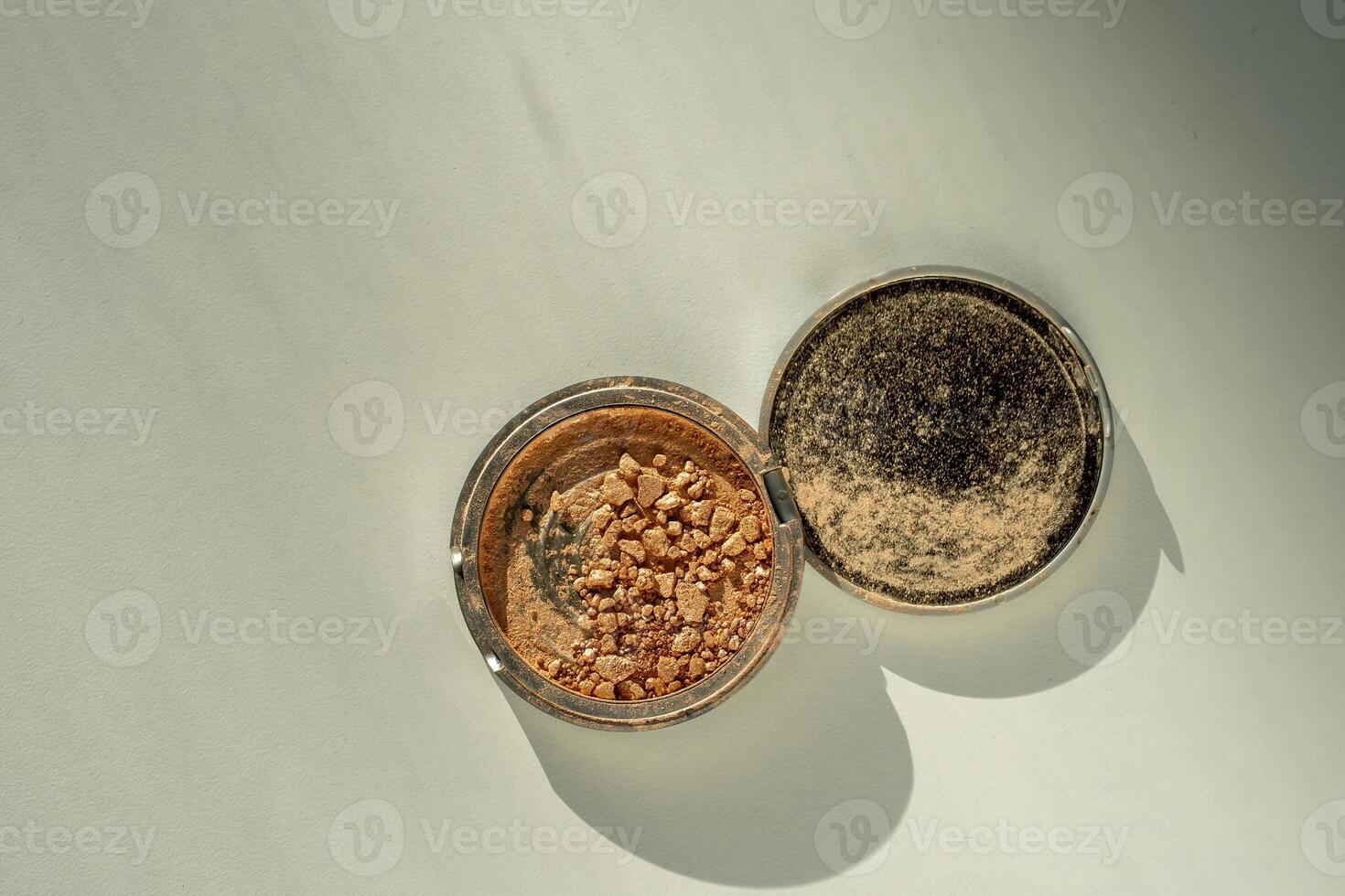 Broken palette with highlighter on a white table. Decorative cosmetics photo