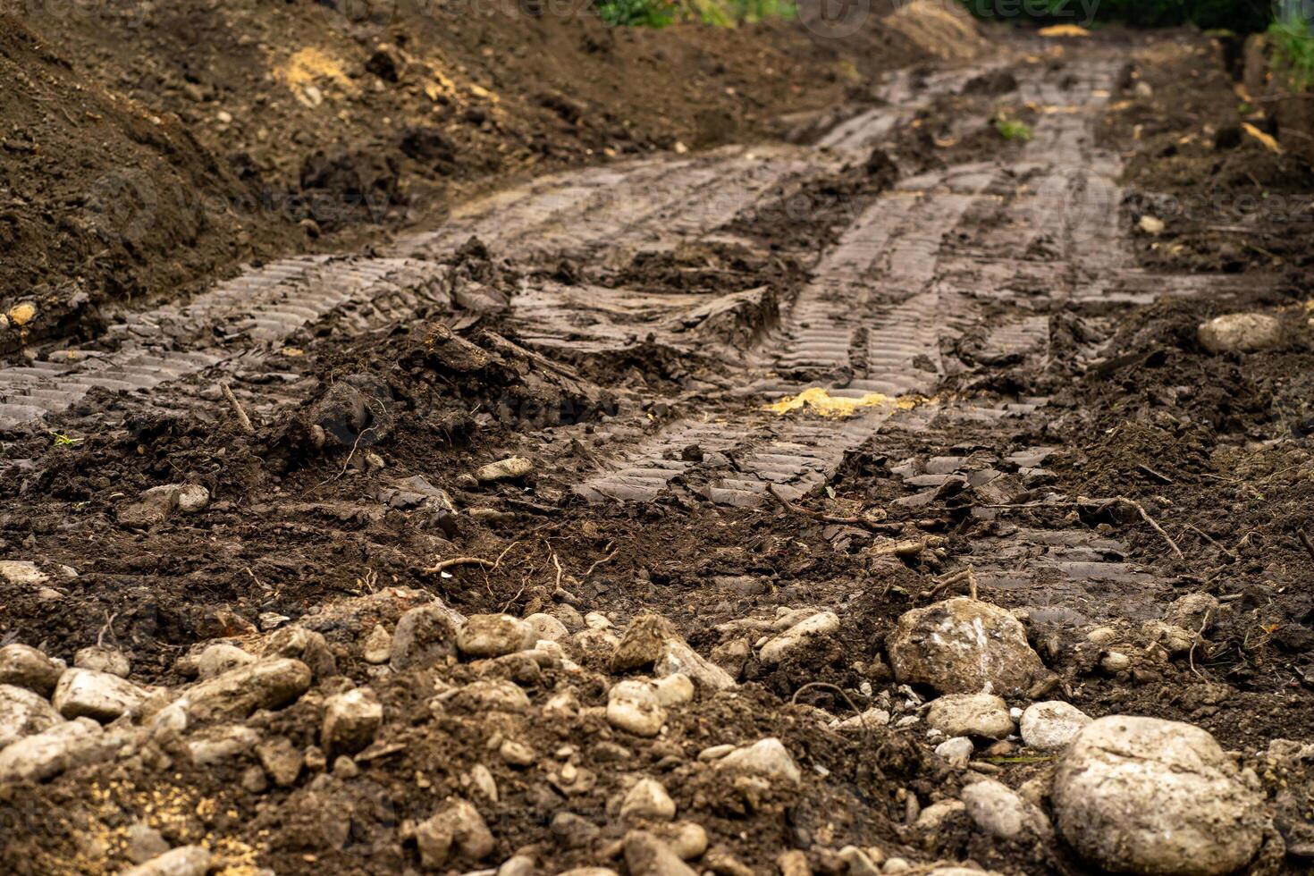 Traces from a passing tractor on the damp ground. Wheel tracks on the ground photo