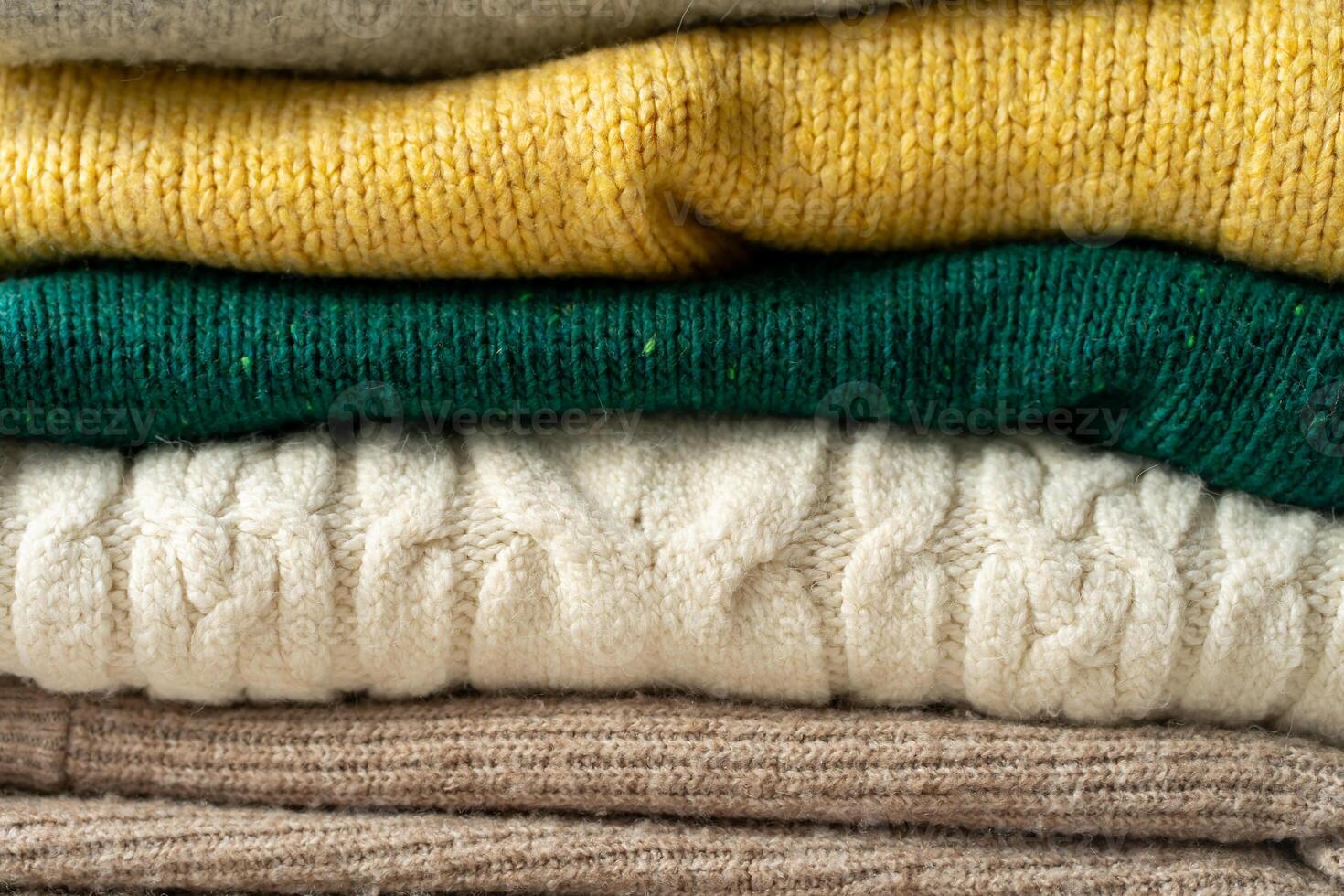 A stack of knitted sweaters on the table. Background textures photo