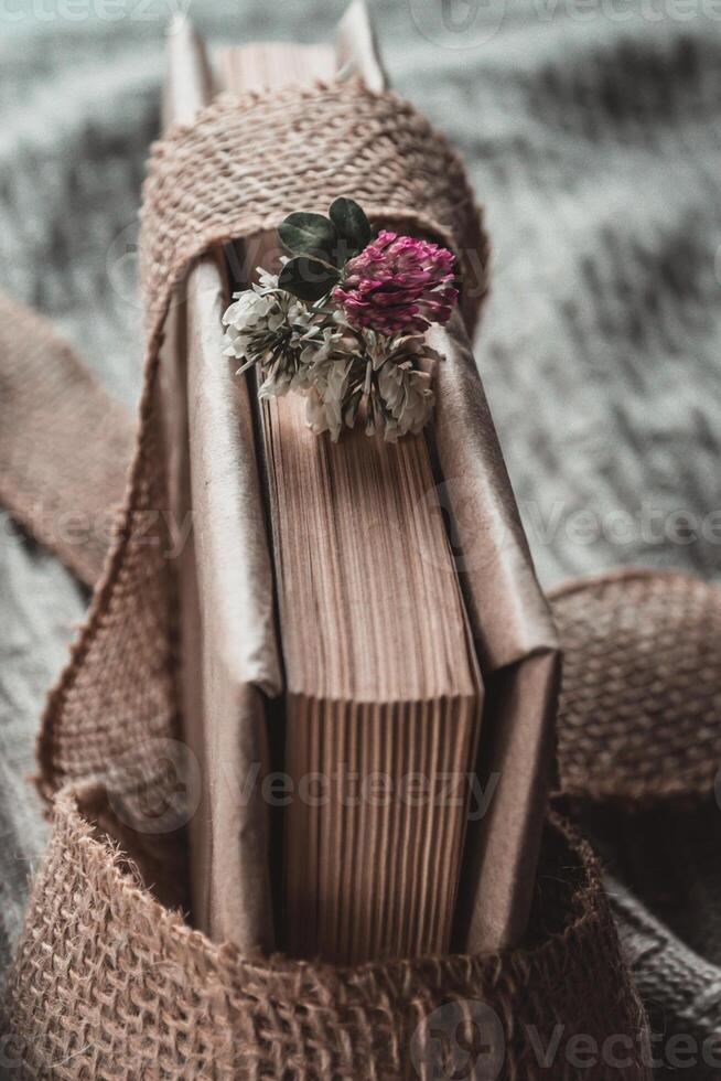 A small bouquet of clover on the butt end of a book on a blurred background photo