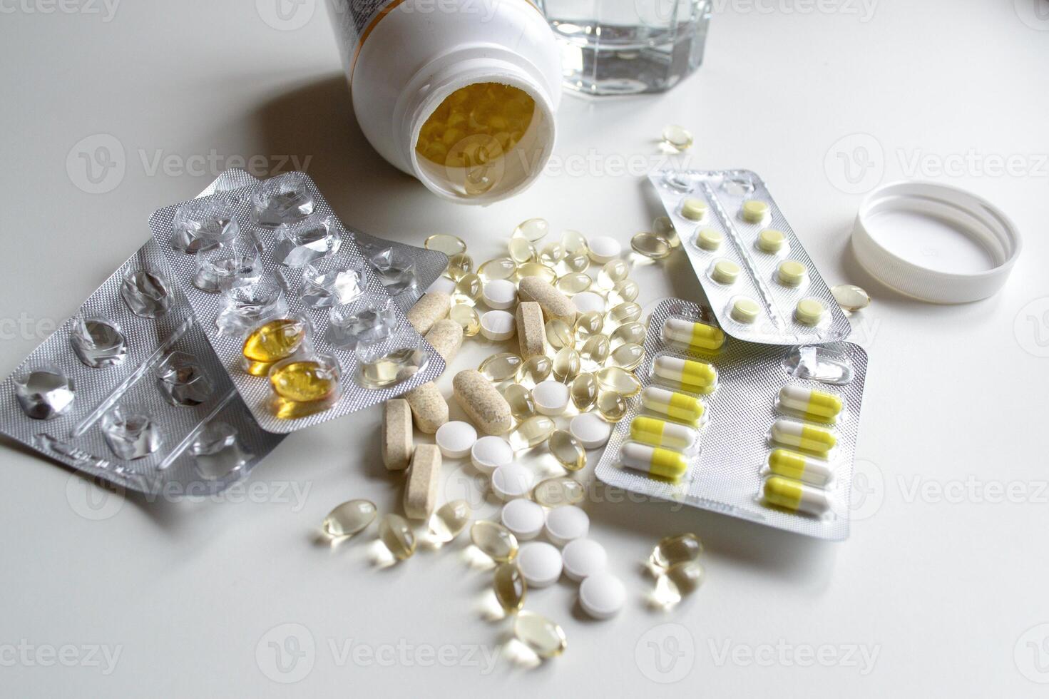 A lot of different vitamins and tablets in packages and without on a white table photo