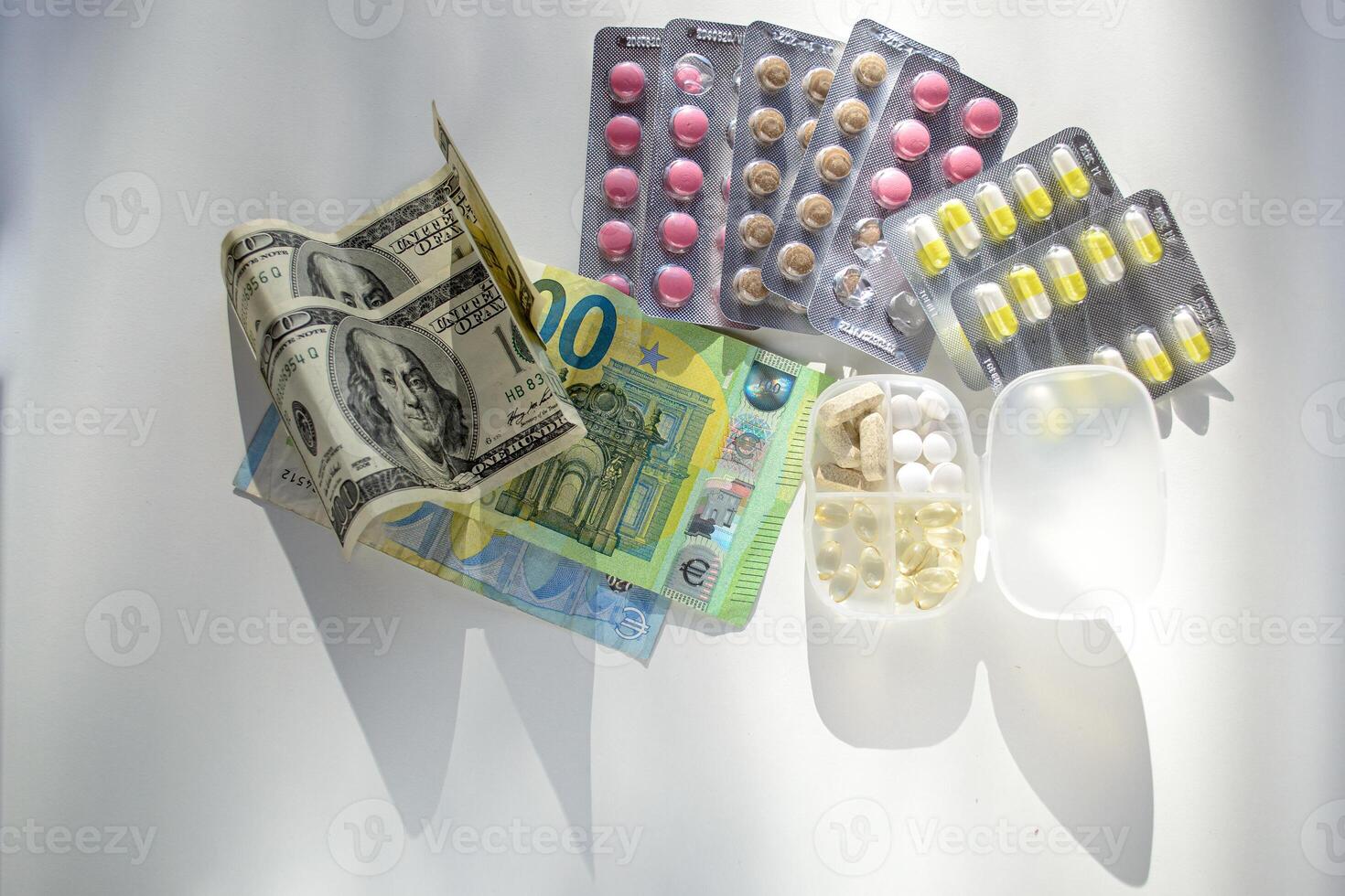 Jelly capsules and hard tablets of vitamin D on dollar bills on a white table photo