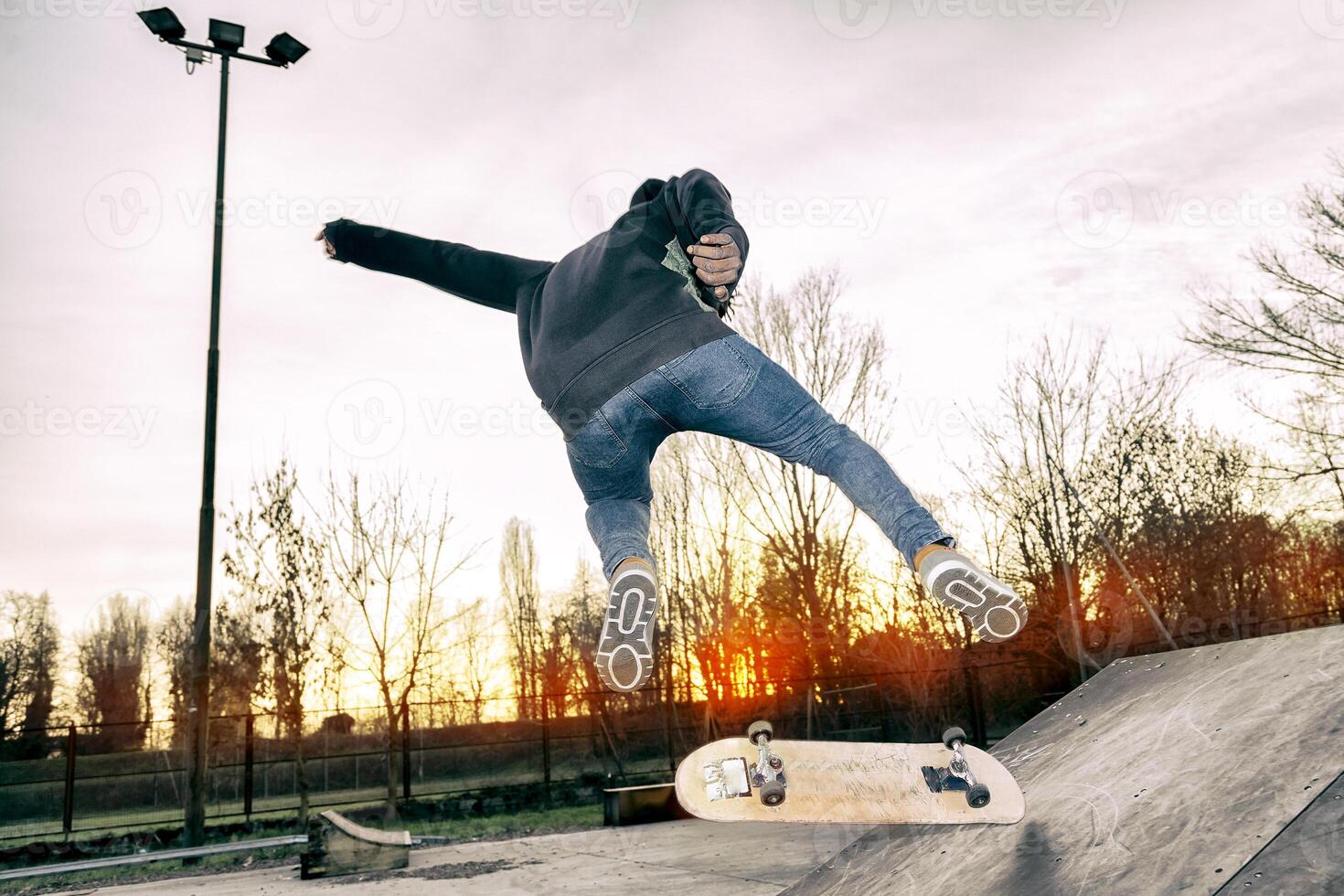 young skateboarder jumping on a ramp outdoor photo