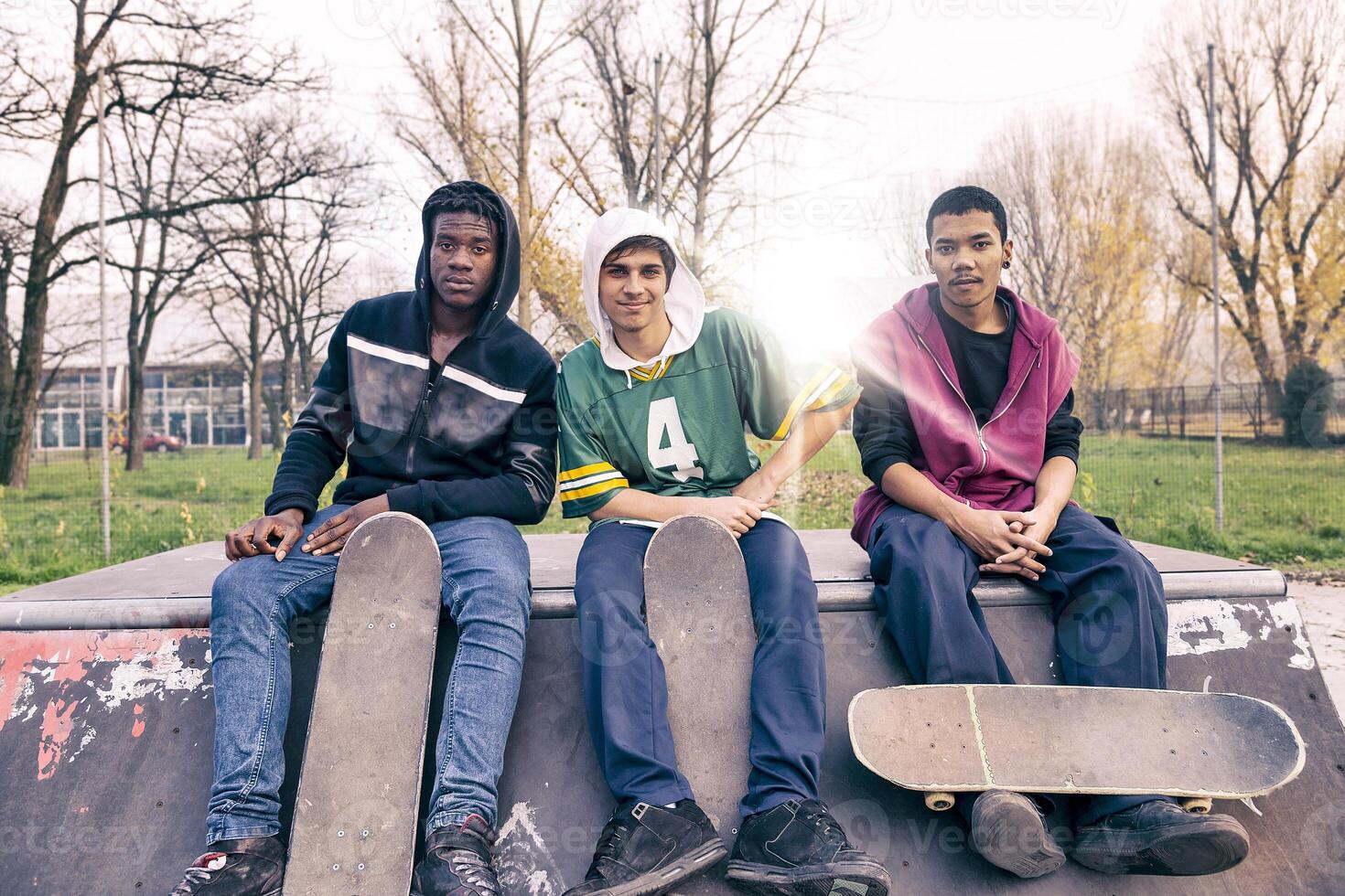 group of young adults sitting on a ramp with skateboard photo