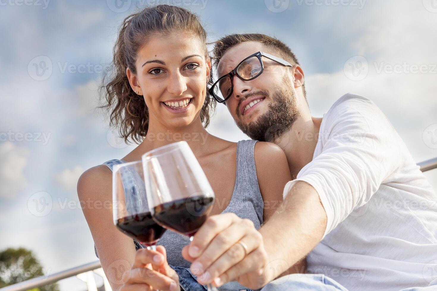 young couple farmers toasts in their vineyard photo