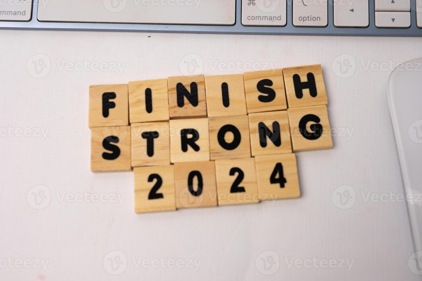 the wooden box says finish strong 2024 neatly arranged on top of white desk photo