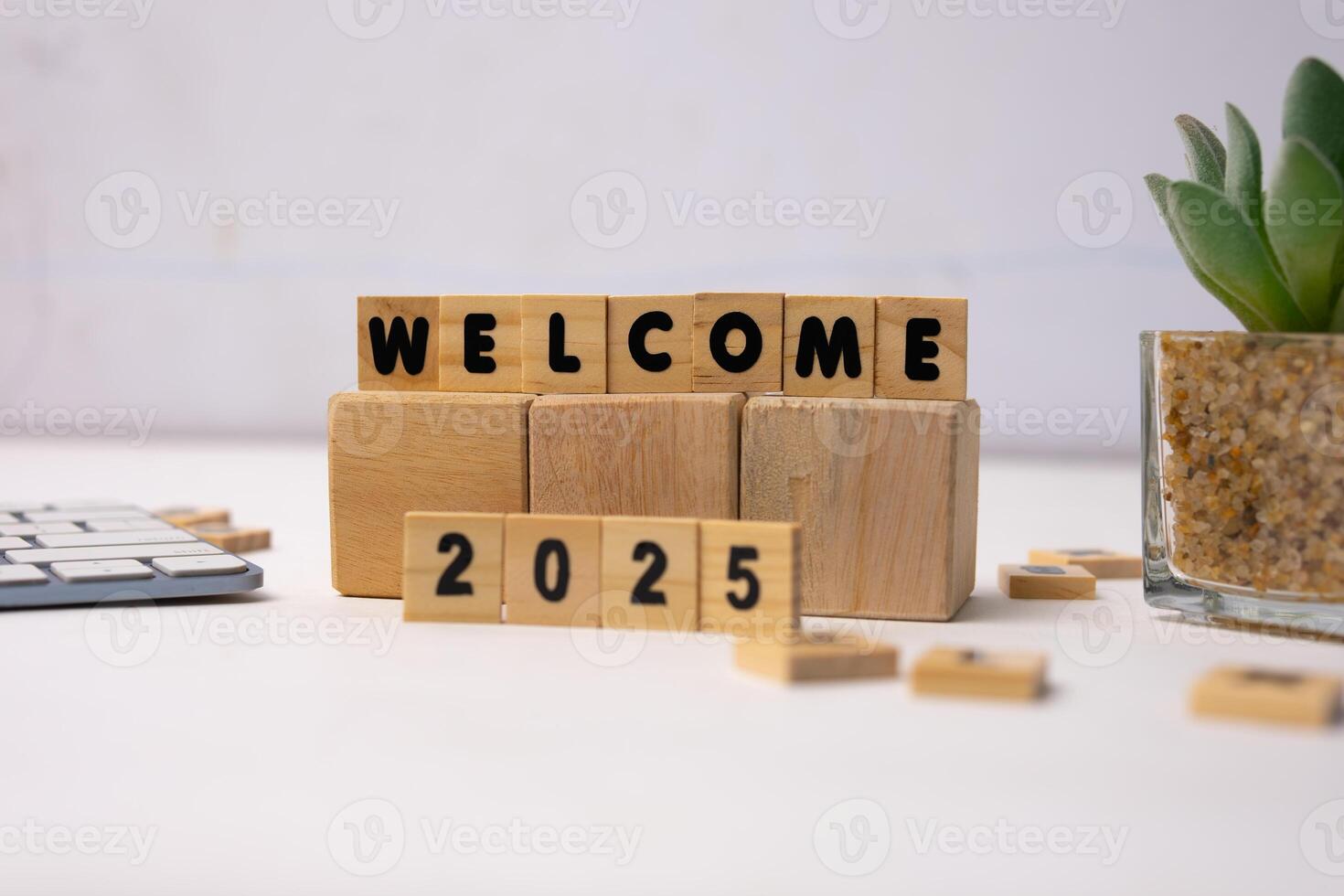 welcome 2025 words on block wood standing in a white desk photo