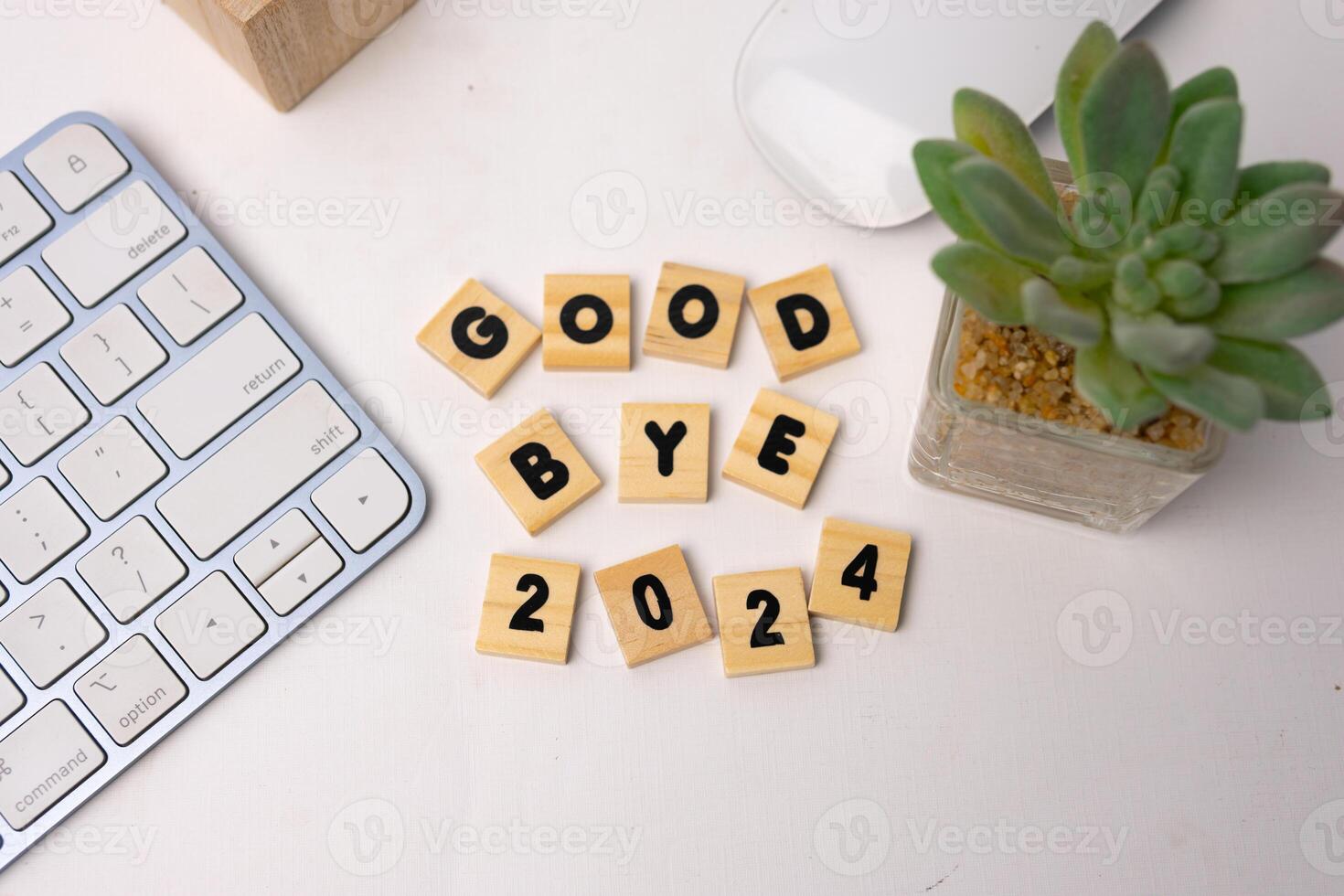 the wooden box says good bye 2024 on top of white desk, top view photo