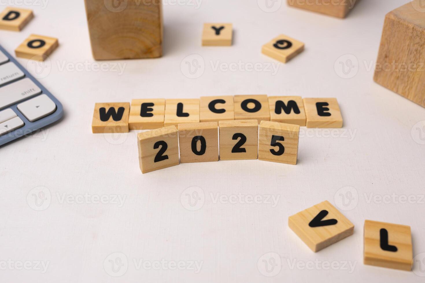 welcome 2025 written in wooden blocks on a white desk photo