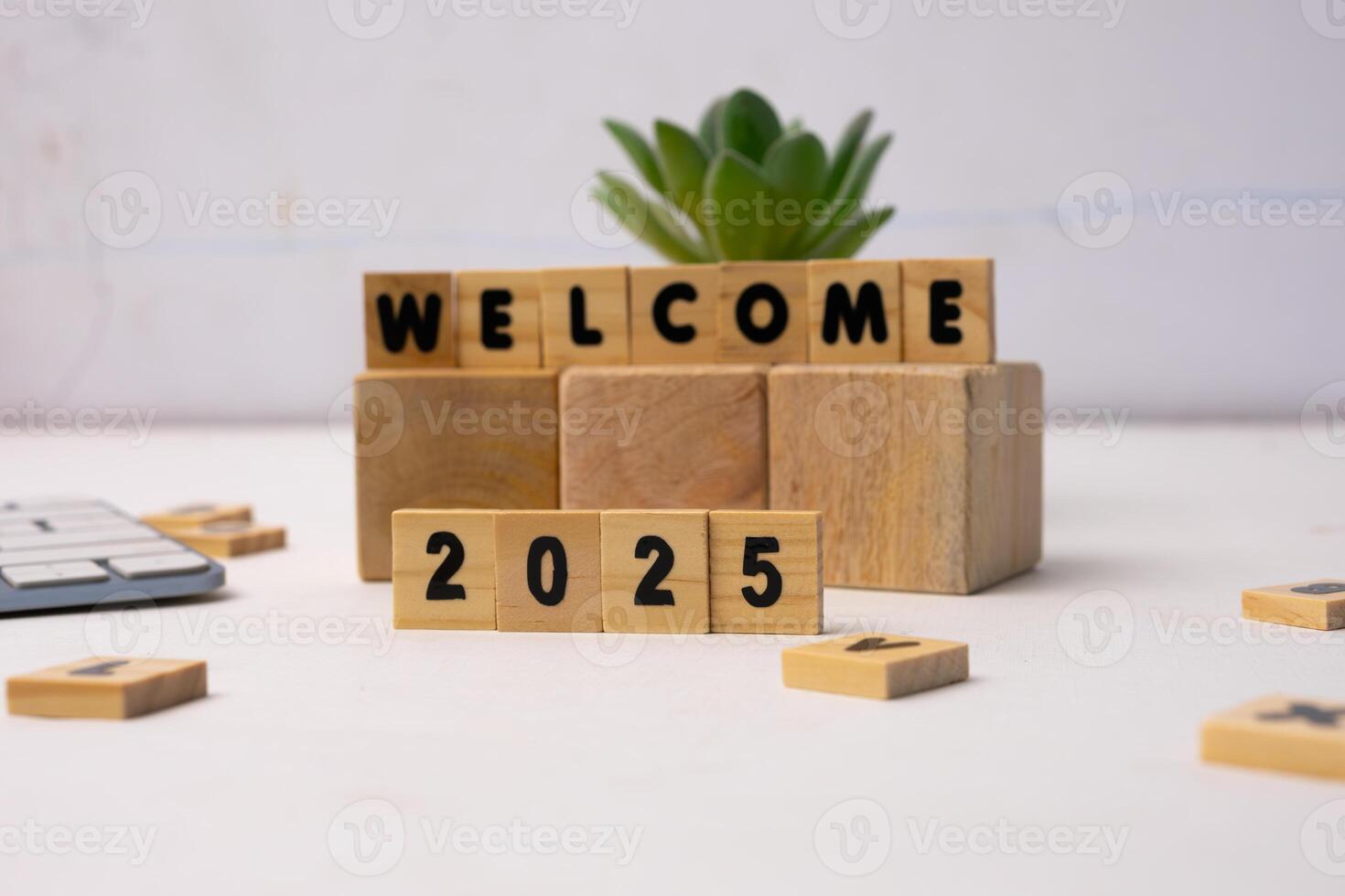welcome 2025 on a brown wood, standing on a white desk photo