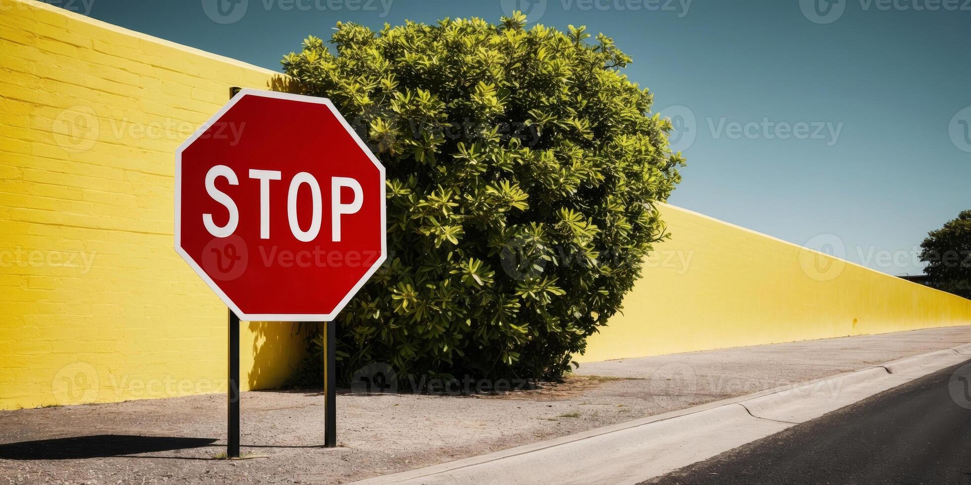 A stop sign is in front of a yellow wall photo