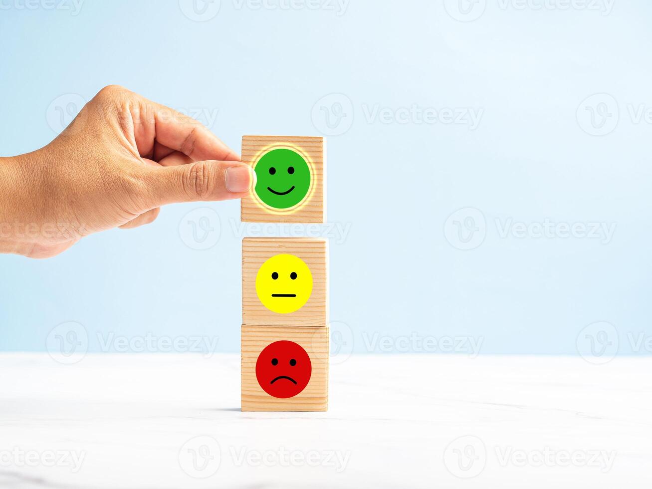 Customer positive feedback. Hand holding a wooden cube with the happy face icon gives the best satisfaction to the service photo