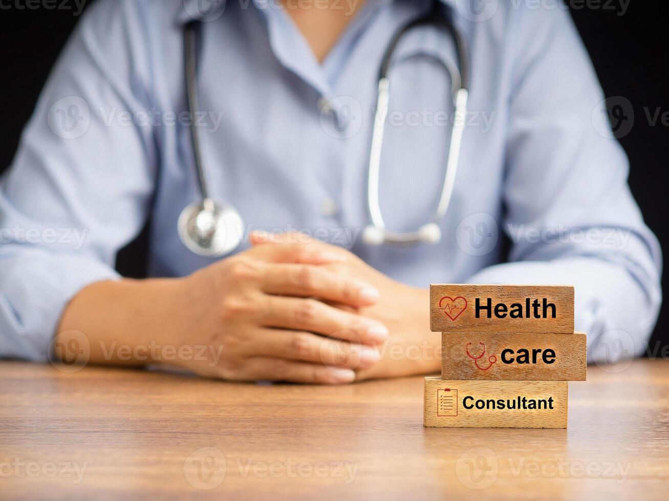 Wooden blocks with the letters Health, Care, and Consultant over a wooden desk with a doctor sitting blurred background photo