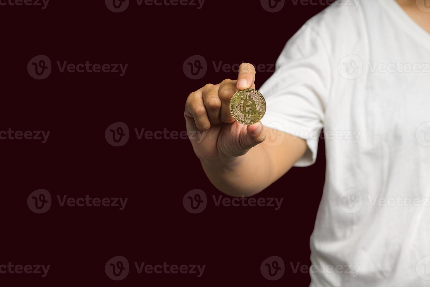 Close-up of hand holding a bitcoin coin while standing over a red background photo